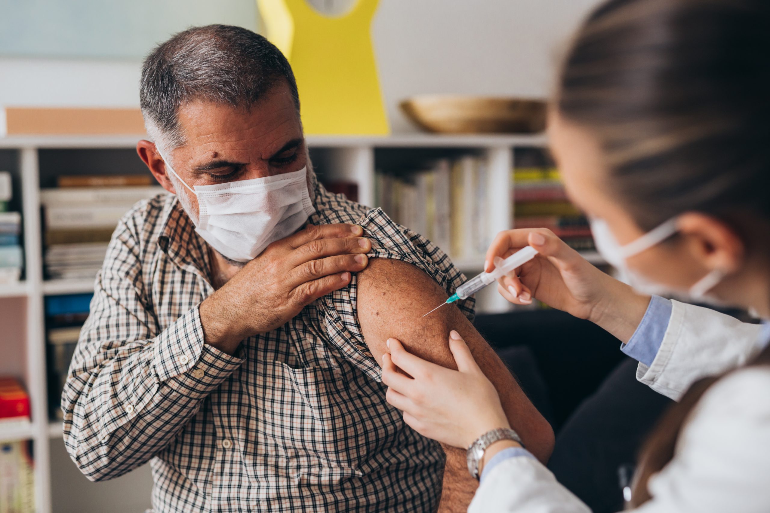 Man being vaccinated at work - workplace vaccination clinic