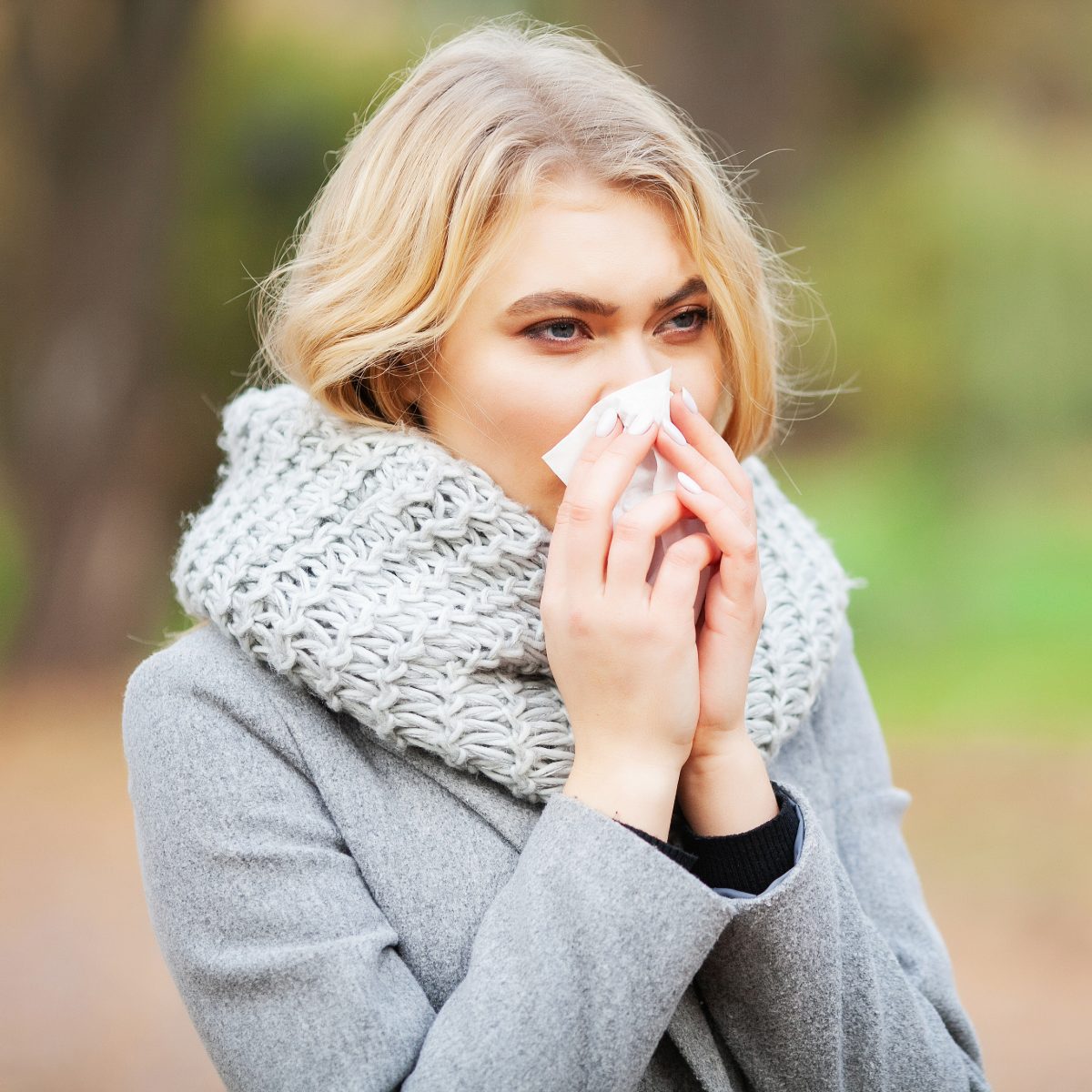Woman with a tissue; what are the differences between the common cold and the flu